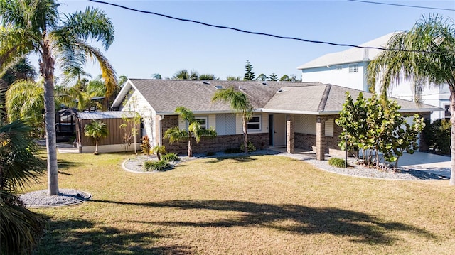 single story home with a front lawn, roof with shingles, and brick siding