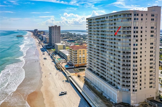 birds eye view of property featuring a water view and a beach view