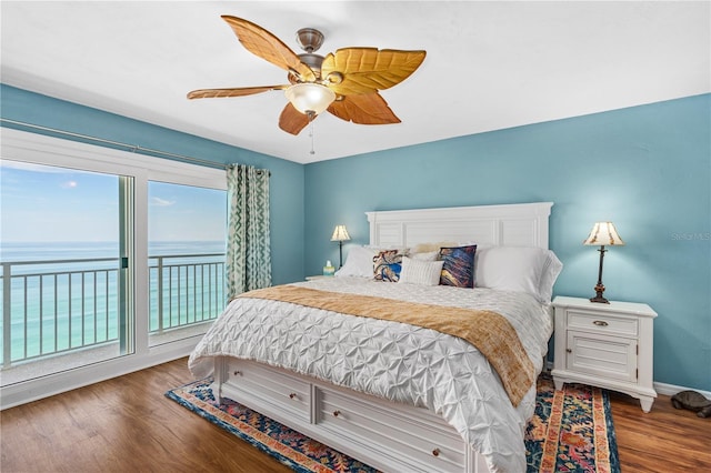 bedroom featuring a water view, access to outside, hardwood / wood-style floors, and ceiling fan