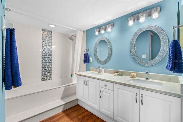 bathroom with hardwood / wood-style flooring, vanity, and shower / bathtub combination with curtain