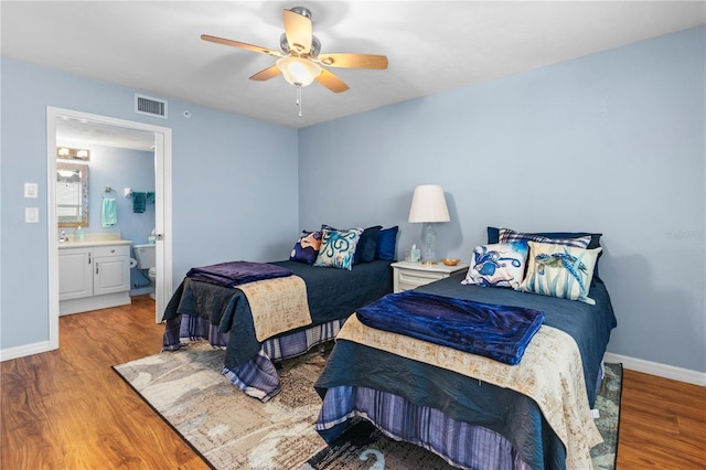 bedroom with hardwood / wood-style flooring, ceiling fan, and ensuite bath