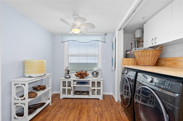 clothes washing area featuring cabinets, washing machine and clothes dryer, ceiling fan, and light hardwood / wood-style flooring