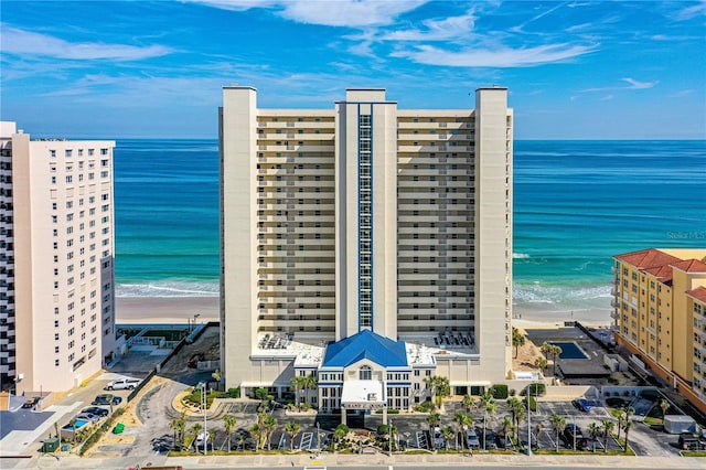 view of building exterior with a water view and a view of the beach