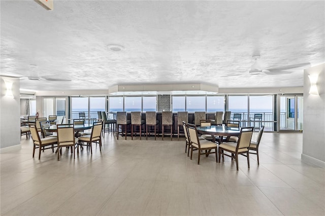 dining room with a water view and a textured ceiling