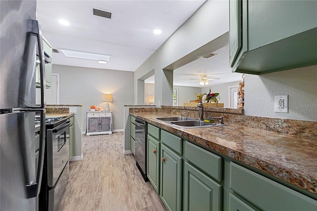 kitchen with stainless steel appliances, sink, kitchen peninsula, and green cabinetry