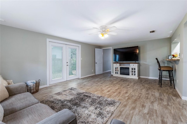 living room featuring ceiling fan and light hardwood / wood-style flooring