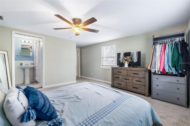 carpeted bedroom featuring sink, ensuite bath, and ceiling fan