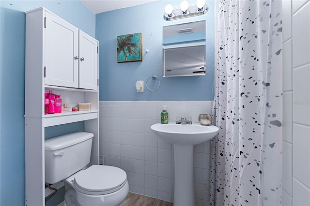 bathroom with sink, hardwood / wood-style flooring, tile walls, a shower with curtain, and toilet