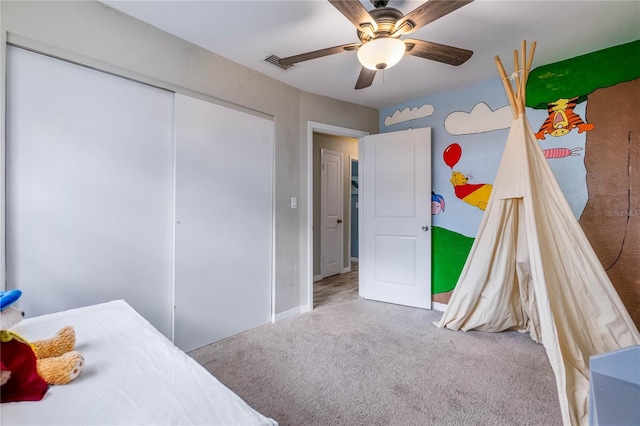 carpeted bedroom with ceiling fan and a closet