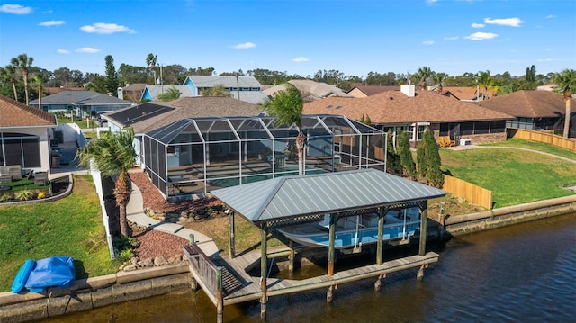 view of dock with a yard, a water view, and a lanai