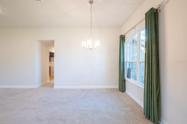 spare room featuring light carpet, baseboards, and a notable chandelier