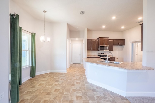 kitchen featuring dark brown cabinetry, visible vents, baseboards, appliances with stainless steel finishes, and a sink