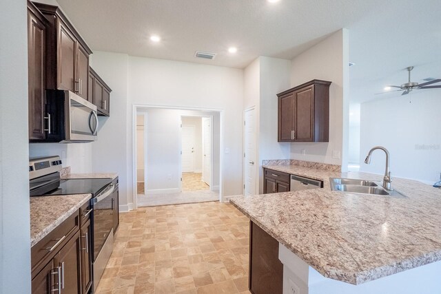 kitchen with stainless steel appliances, visible vents, a sink, dark brown cabinetry, and a peninsula