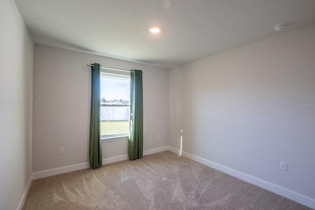 empty room with light carpet and baseboards