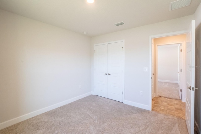 unfurnished bedroom with carpet, visible vents, and baseboards