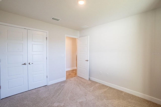 unfurnished bedroom with a closet, baseboards, visible vents, and carpet flooring