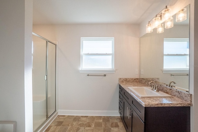 bathroom featuring baseboards, vanity, and a shower stall