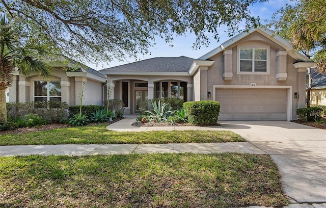 view of front of house with concrete driveway, an attached garage, and stucco siding