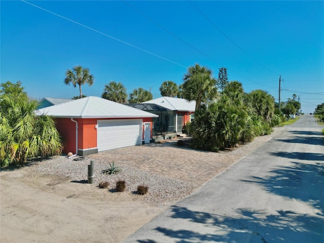 view of front of house featuring decorative driveway, a garage, and metal roof