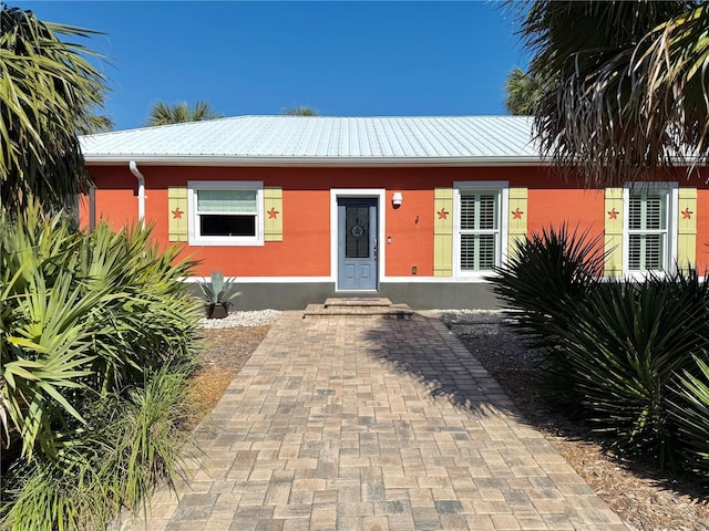 view of front of property with brick siding and metal roof