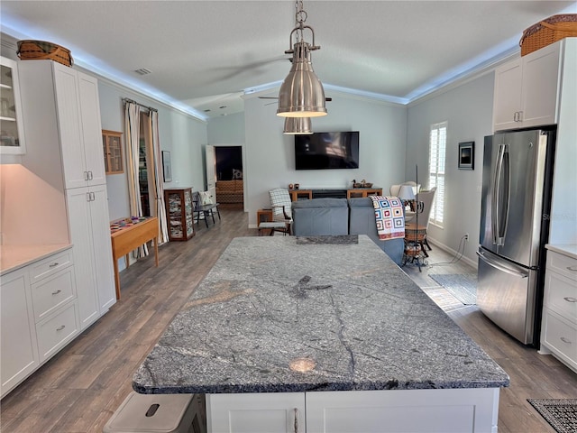 kitchen featuring white cabinetry, dark stone countertops, wood finished floors, and freestanding refrigerator