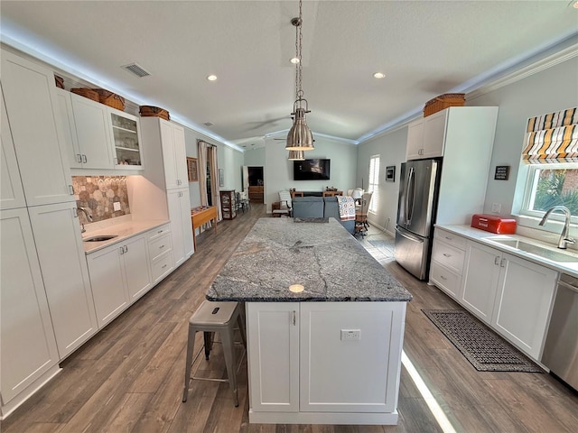 kitchen with ornamental molding, stainless steel appliances, and a sink