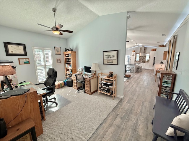 office space with ceiling fan, lofted ceiling, a textured ceiling, and wood finished floors