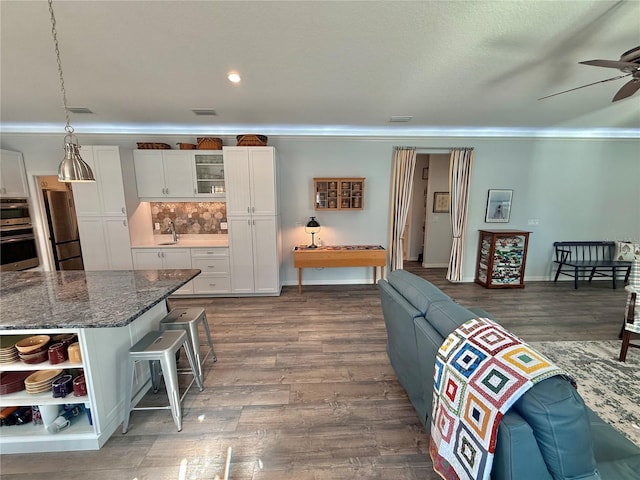 living room featuring baseboards, dark wood-type flooring, and a ceiling fan