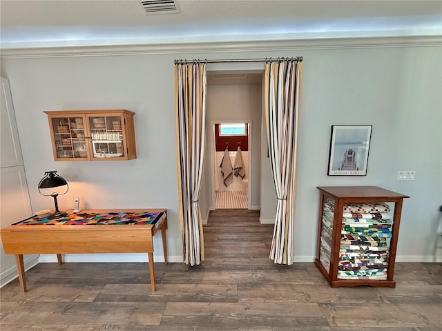 corridor with visible vents, baseboards, and wood finished floors