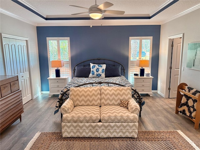 bedroom with wood finished floors, a textured ceiling, and ornamental molding