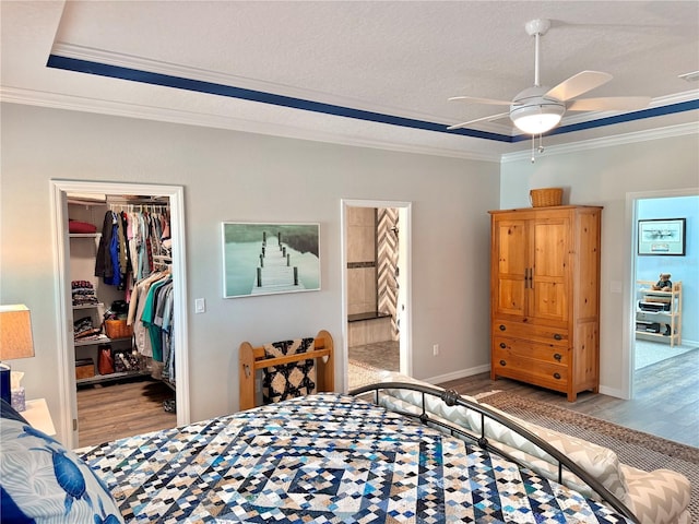 bedroom featuring a raised ceiling, crown molding, and wood finished floors