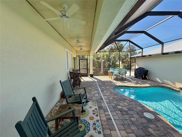 pool with a patio area, glass enclosure, a grill, and a ceiling fan