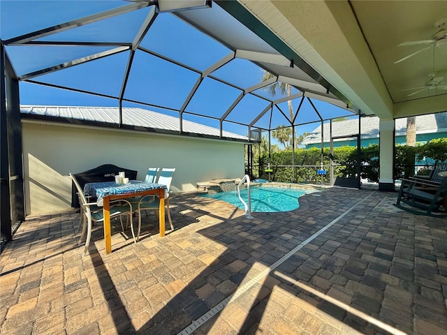 outdoor pool with a ceiling fan, a jacuzzi, glass enclosure, and a patio area