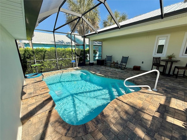 outdoor pool featuring glass enclosure and a patio area