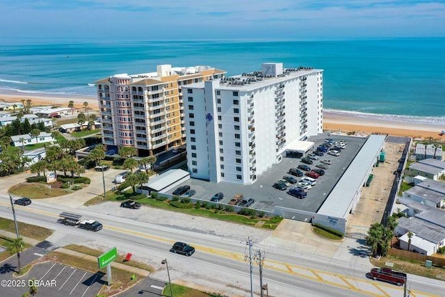 birds eye view of property featuring a water view and a beach view