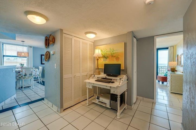 home office with light tile patterned flooring, a wealth of natural light, and a textured ceiling