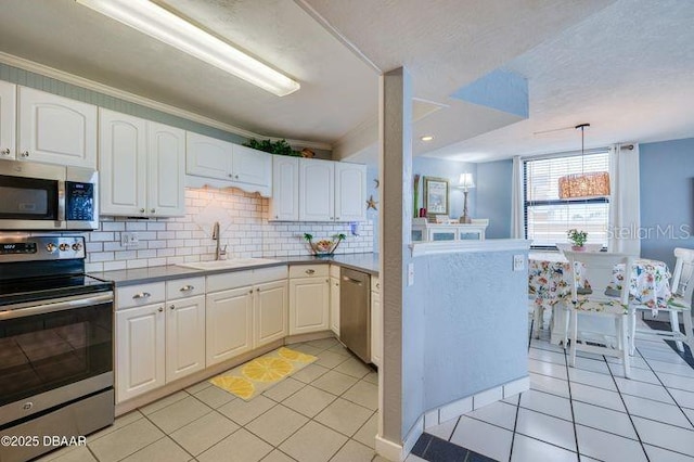 kitchen with white cabinetry, appliances with stainless steel finishes, sink, and hanging light fixtures