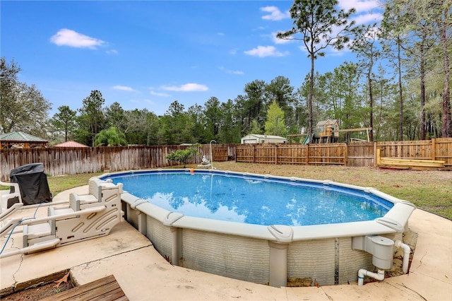 view of swimming pool with a fenced backyard, a playground, and a fenced in pool