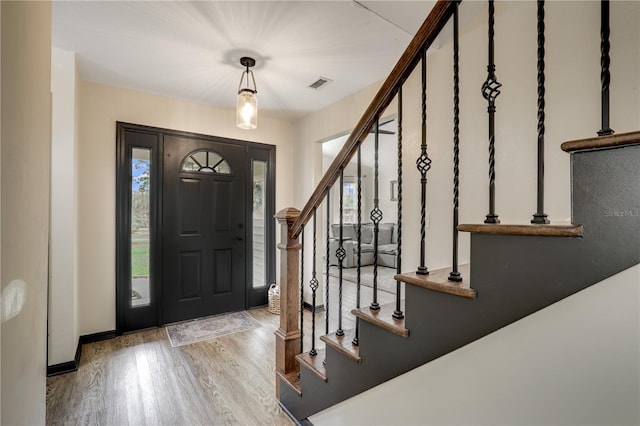 entrance foyer featuring light wood finished floors, stairway, visible vents, and baseboards