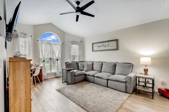 living room featuring light wood-style floors, vaulted ceiling, and ceiling fan