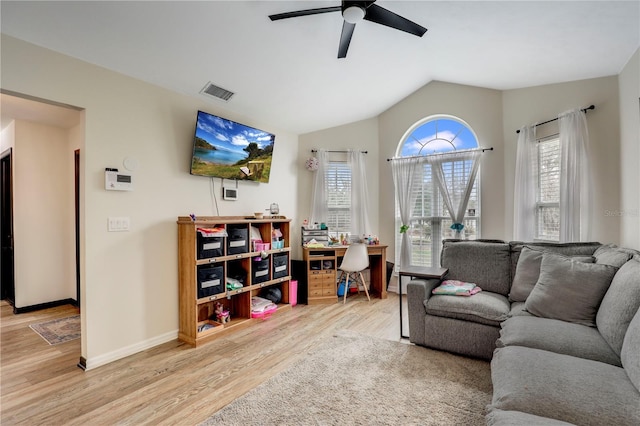 living room with visible vents, light wood-style floors, a ceiling fan, vaulted ceiling, and baseboards