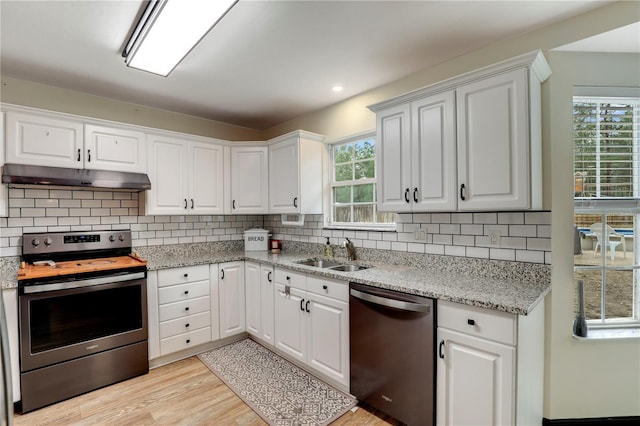 kitchen featuring under cabinet range hood, a sink, white cabinets, appliances with stainless steel finishes, and decorative backsplash