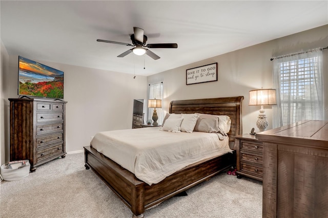 bedroom with light carpet, ceiling fan, and baseboards