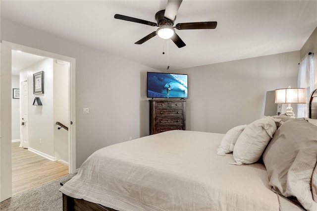 bedroom featuring ceiling fan, light wood finished floors, and baseboards