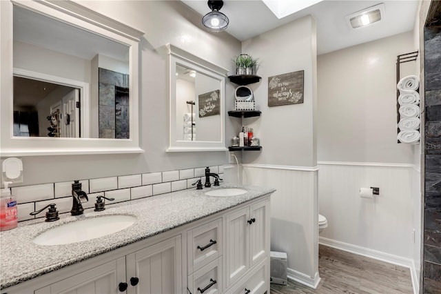 bathroom featuring a wainscoted wall, visible vents, a sink, and toilet