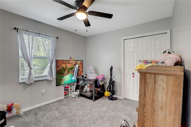 playroom with ceiling fan, carpet floors, and baseboards