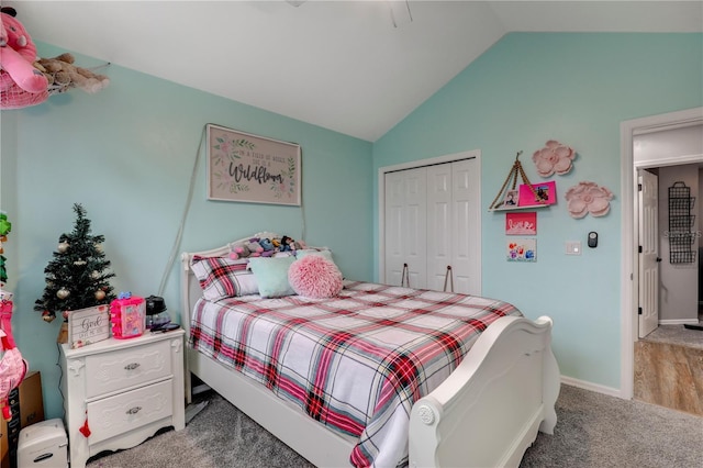 bedroom with lofted ceiling, a closet, carpet flooring, and baseboards