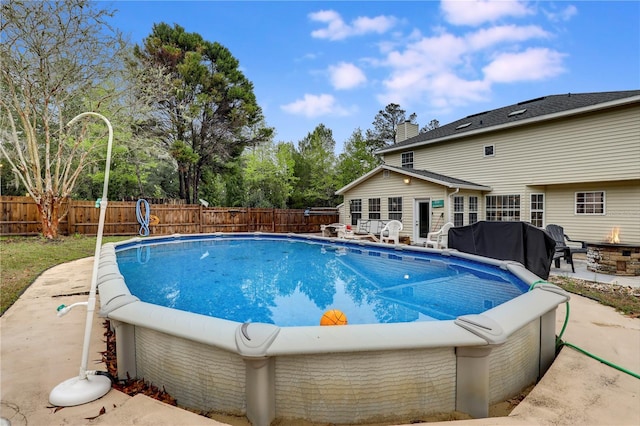 view of pool with an outdoor fire pit, a fenced backyard, and a fenced in pool