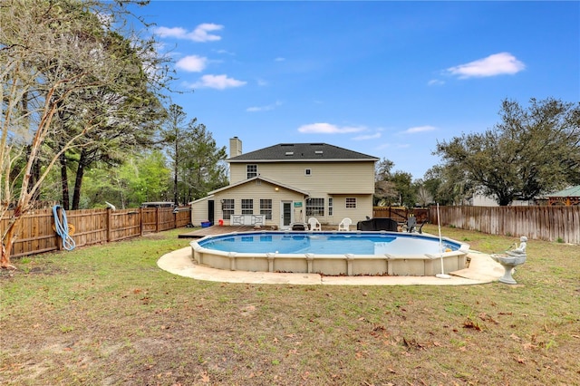 view of swimming pool featuring a fenced backyard, a lawn, and a fenced in pool