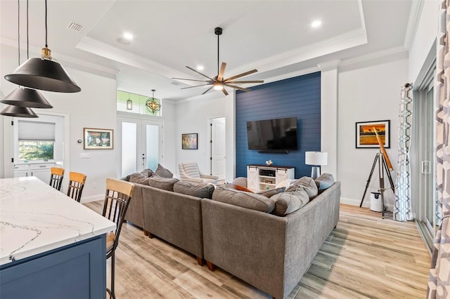 living room featuring ornamental molding, french doors, a raised ceiling, and visible vents